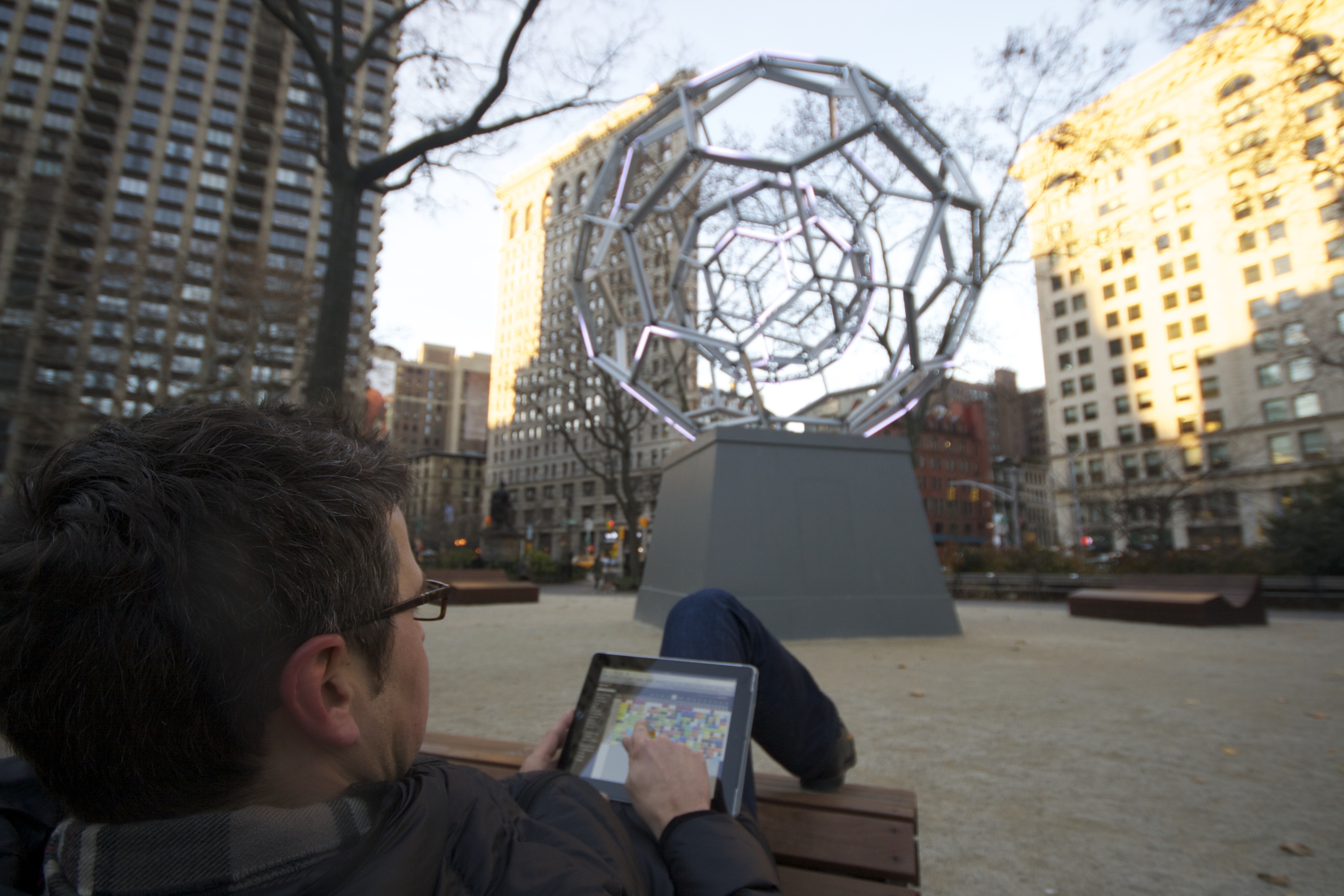 Im Madison Square Park, das Flatiron Building im Hintergrund, in einem der Lounge Chairs einen Blick auf den Belegungsplan werfen.